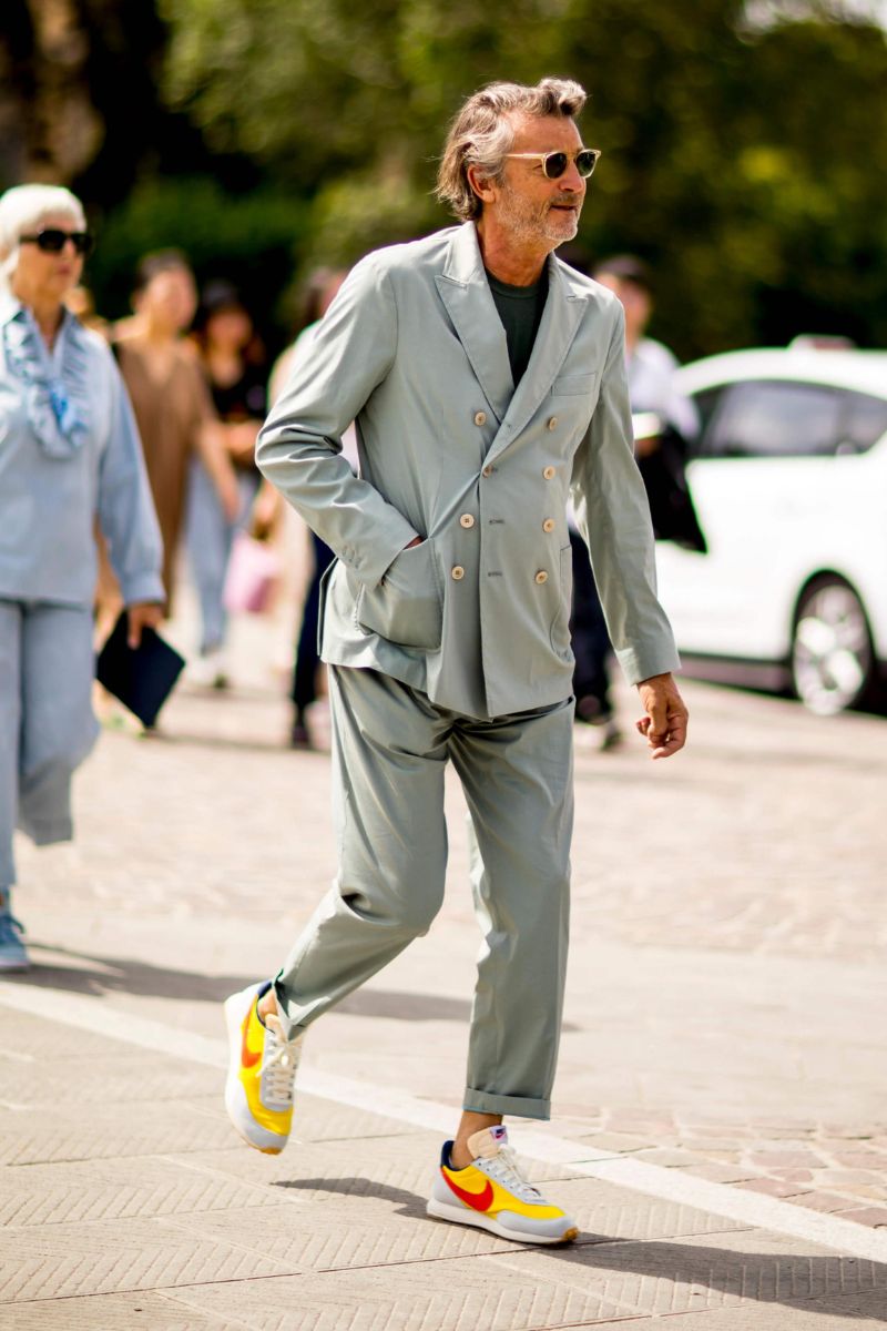 Homem usando um look de inverno masculino composto por alfaiataria e tênis esportivo colorido da marca Nike