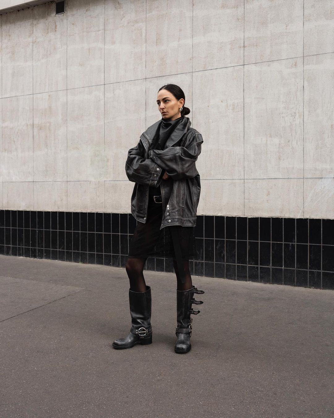 Mulher usando um look que exemplifica como usar bota biker com couro e transparência