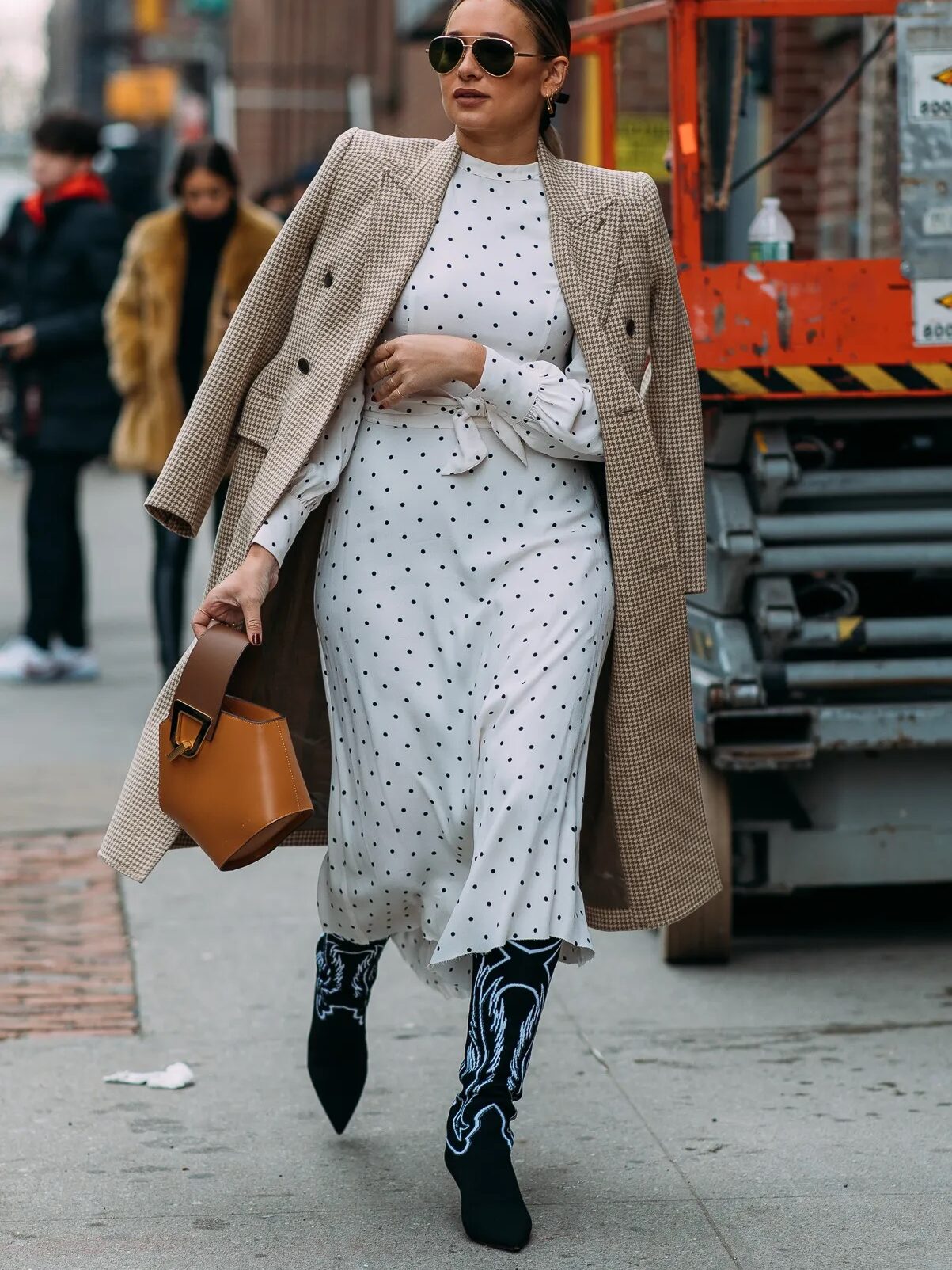 Mulher usando um look despojado mostrando como usar bota texana com combinação de diferentes estampas