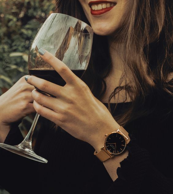 Mulher tomando uma taça de vinho feliz por ter recebido ideias de presente dia dos namorados