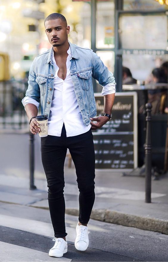 Homem usando um look com jaqueta jeans masculina de lavagem clara e camisa branca de botão