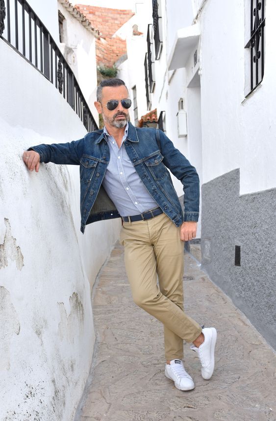 Homem usando um look com jaqueta jeans masculina e calça de alfaiataria de cor clara