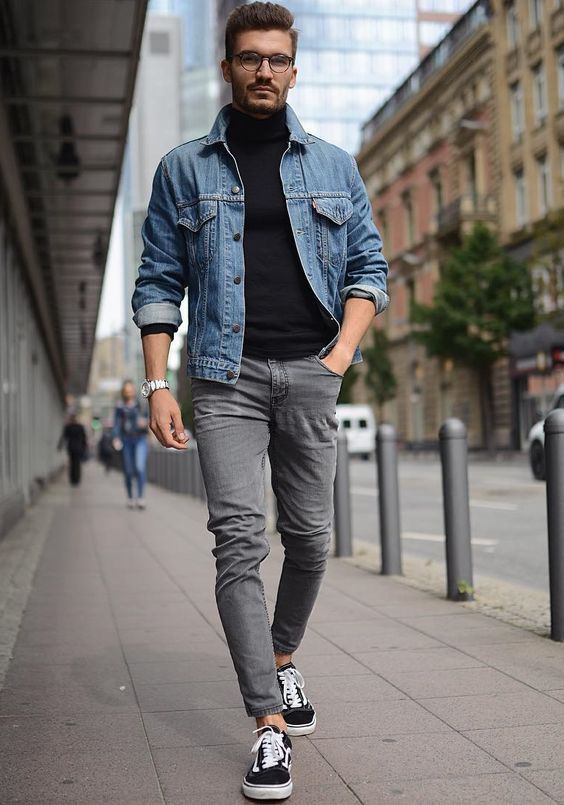 Homem branco usando óculos de grau num look com jaqueta jeans masculina com cores diferentes de jeans