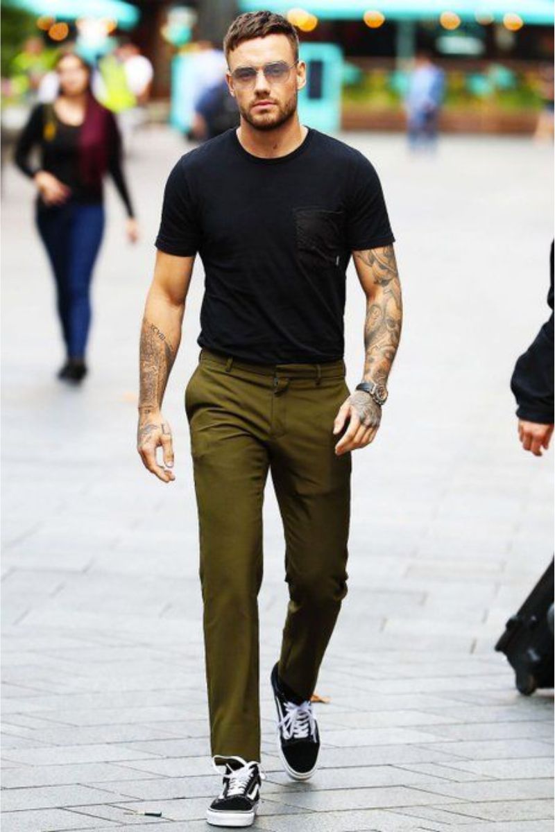 Homem usando look casual masculino calça chino cor oliva e camiseta preta básica