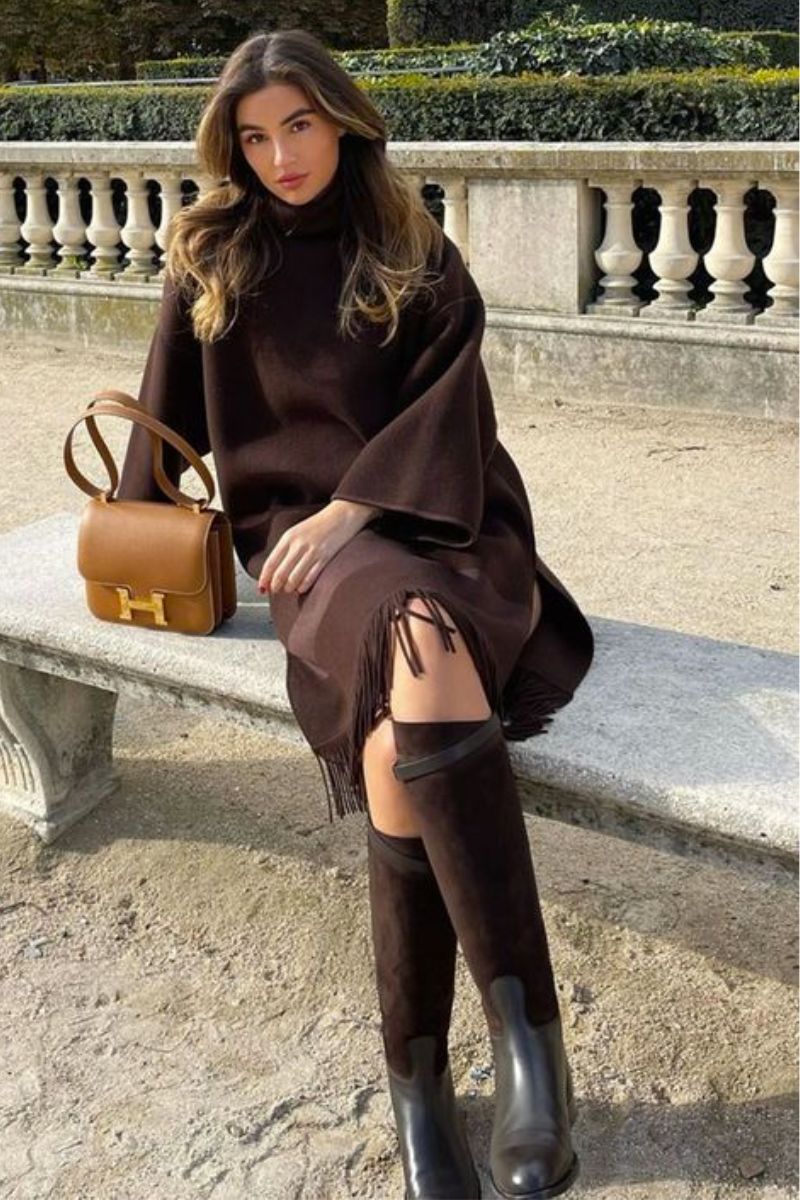 Mulher usando uma parca de cor marrom e um modelo de bota montaria também marrom