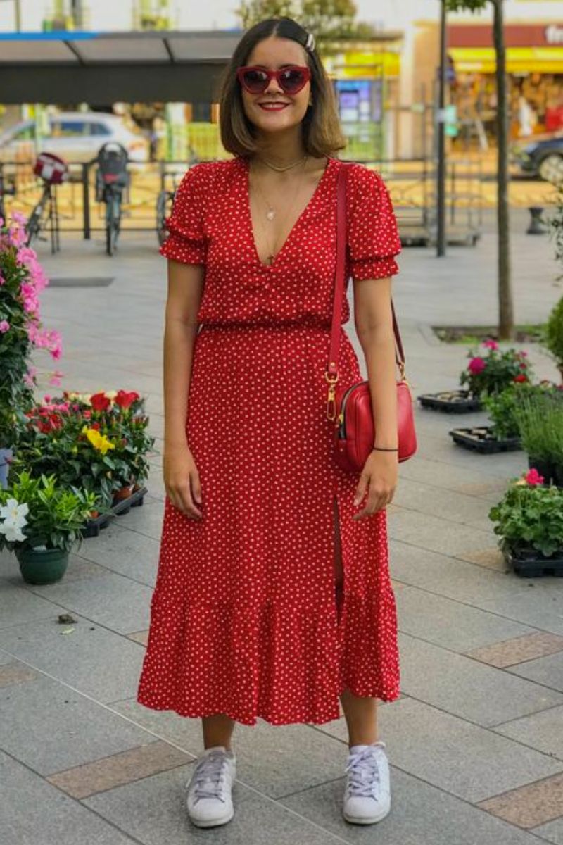 Mulher de cabelos curtos e lisos usando um look que responde à pergunta: vestido vermelho combina com que cor de sapato