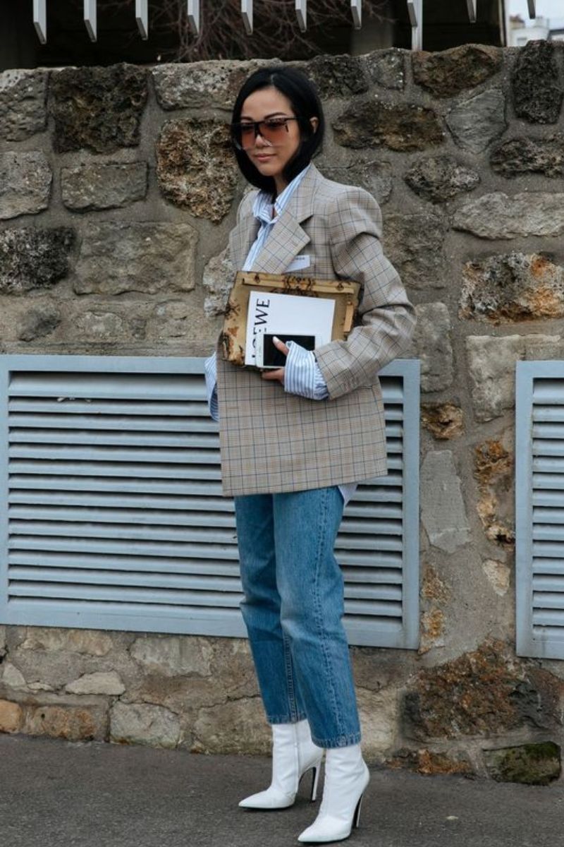 Mulher asiática usando óculos escuros e de cabelos curtos mostrando como usar bota off white com blazer