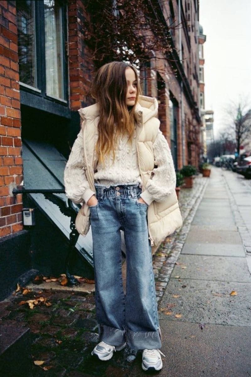 Menina usando um look de inverno infantil feminino composto por suéter de lã e jaqueta puffer