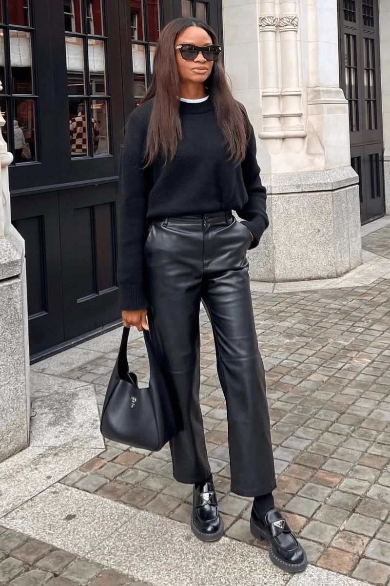 Mulher negra de cabelos lisos usando um look com mocassim tratorado com calça de couro