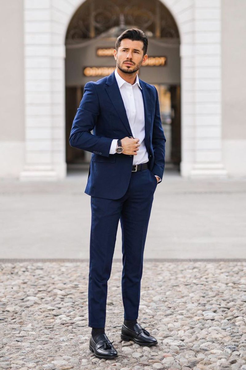 Homem branco exemplificando como usar mocassim masculino com terno azul escuro