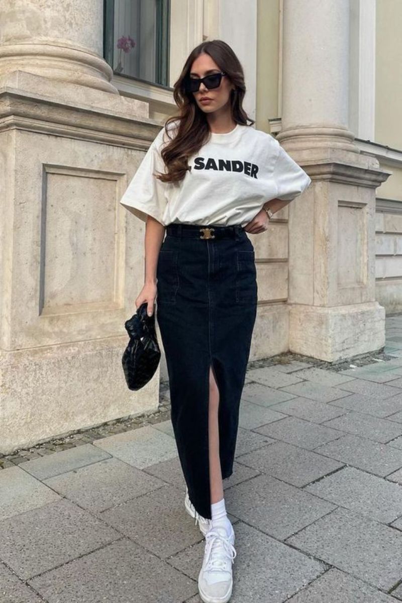 Mulher branca de cabelos castanhos usando tênis confortável para trabalhar com um look composto por saia lápis longa e camiseta branca