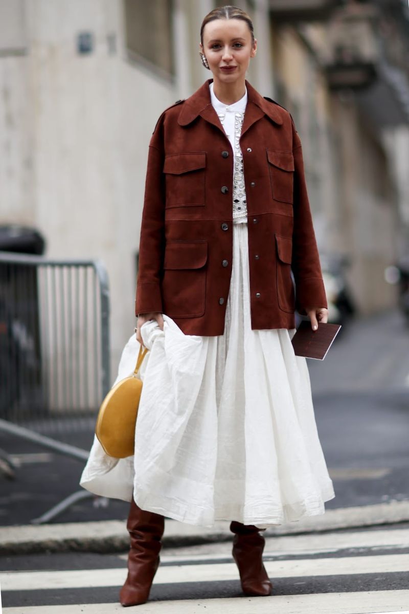 Mulher de cabelos presos dando um exemplo de o que é estilo boho com saia longa