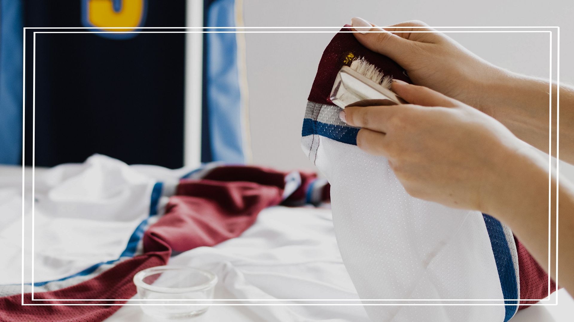 Mãos de uma pessoa ensinando como lavar camisa de time sem estragá-la