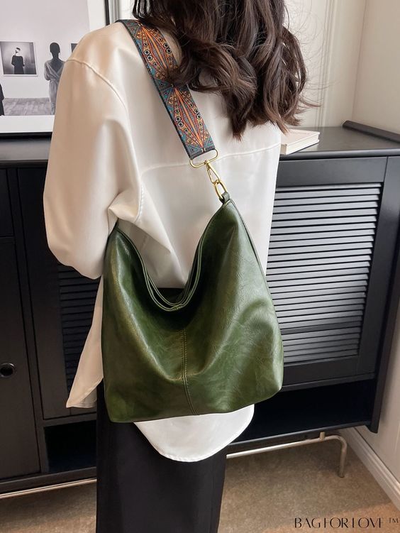 Mulher morena virada de costas usando um look com bolsa verde no estilo hobo bag