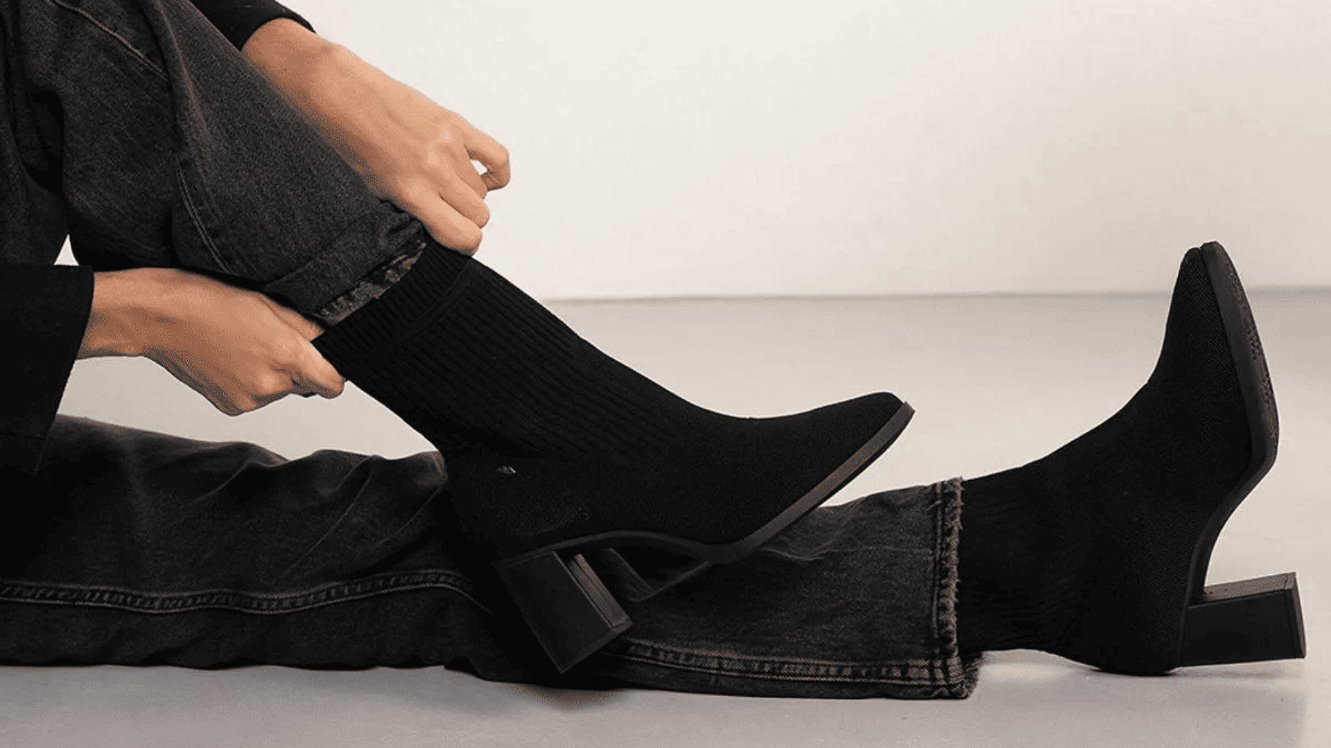 Modelo usando calça jeans e bota preta de salto alto para ilustrar as melhores marcas de botas femininas